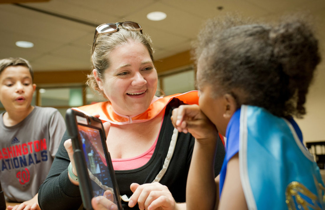 campers working with their counselor on the computer