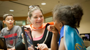 campers working with their counselor on the computer
