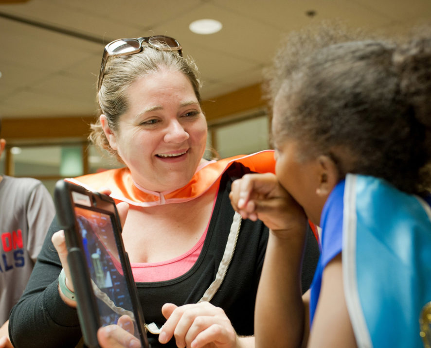 campers working with their counselor on the computer