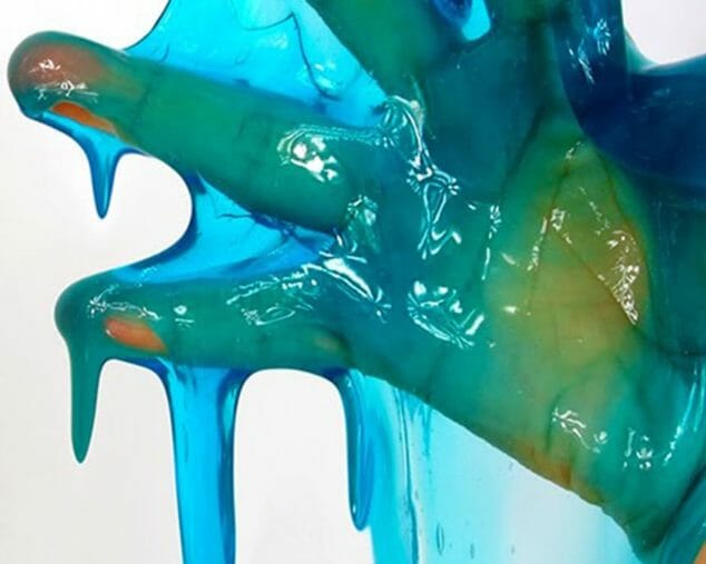 Kid's hand covered in blue and green slime for STEM