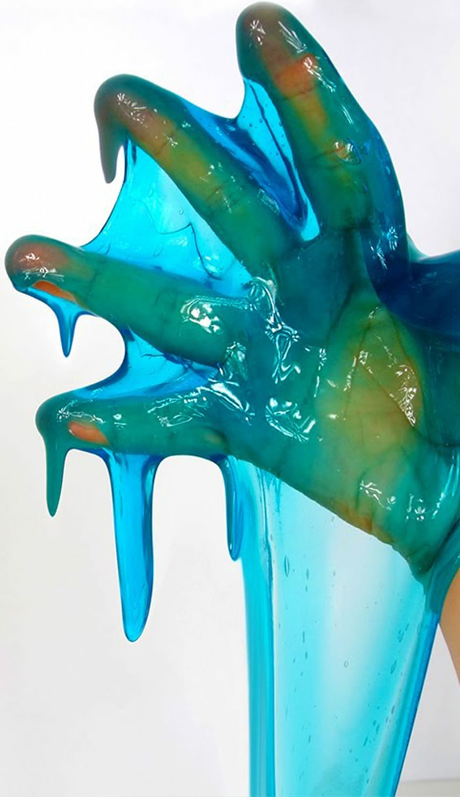 Kid's hand covered in blue and green slime for STEM