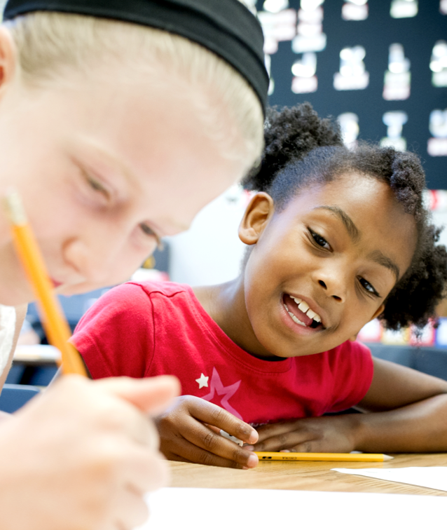 two girls working on a worksheet together at summer camp