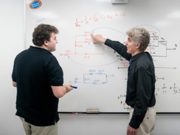 Staff and student working at a whiteboard during the Algebra Review program