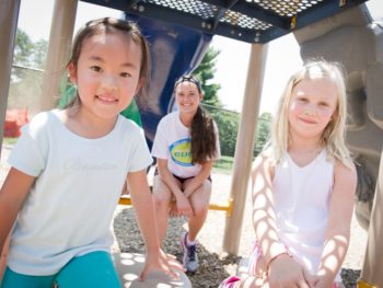 Two girls and staff playing on the playground