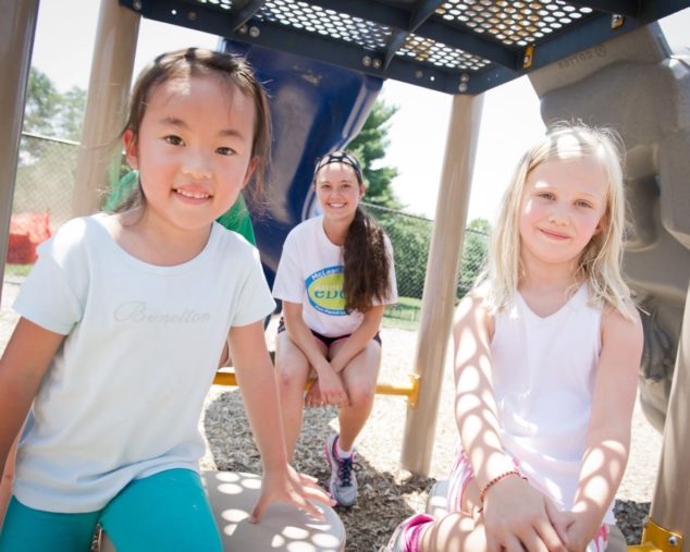 Two girls and staff playing on the playground