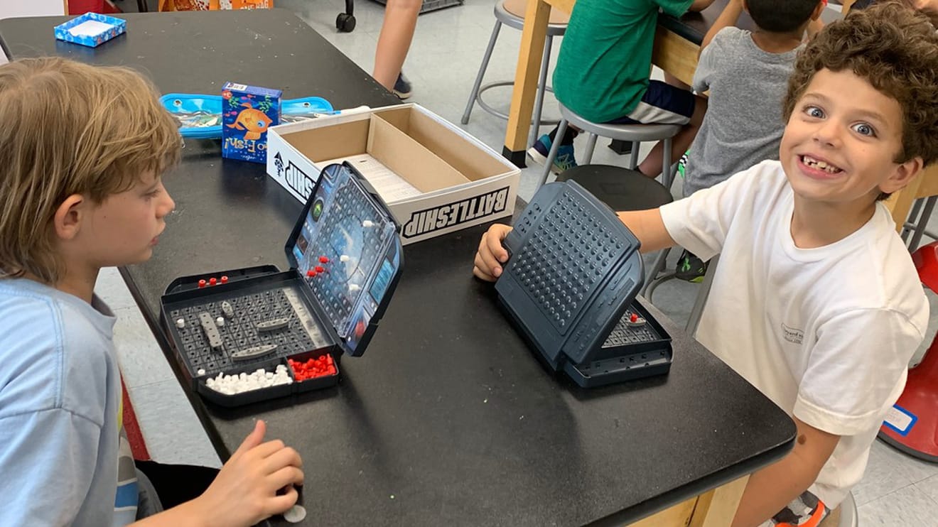 Boys playing battleship at extended care