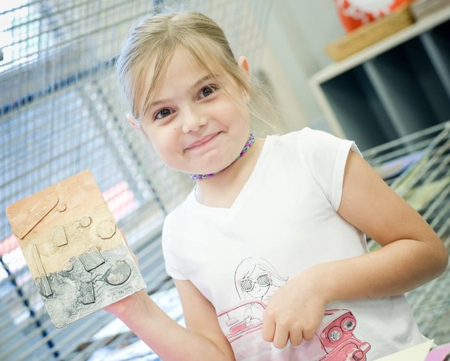 Girl holding up an art project she made