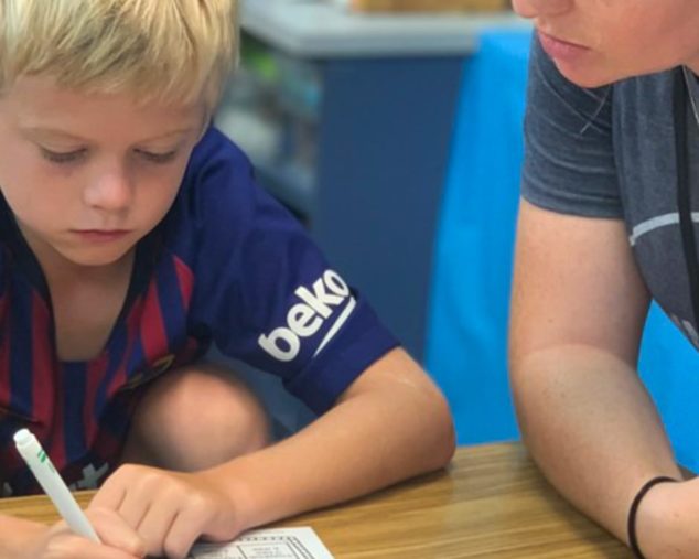 Staff helping male student at the Learning Leaps program