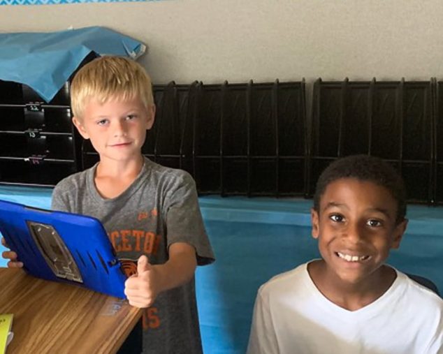 Two boys learning writing techniques on the computer