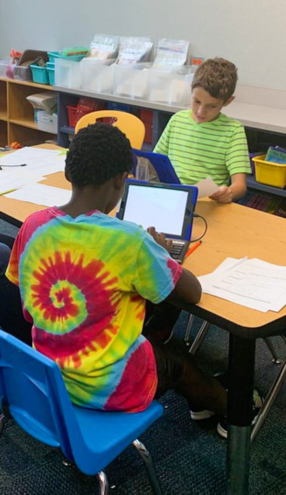 Boys sitting at a table with iPad during the Master Mind program