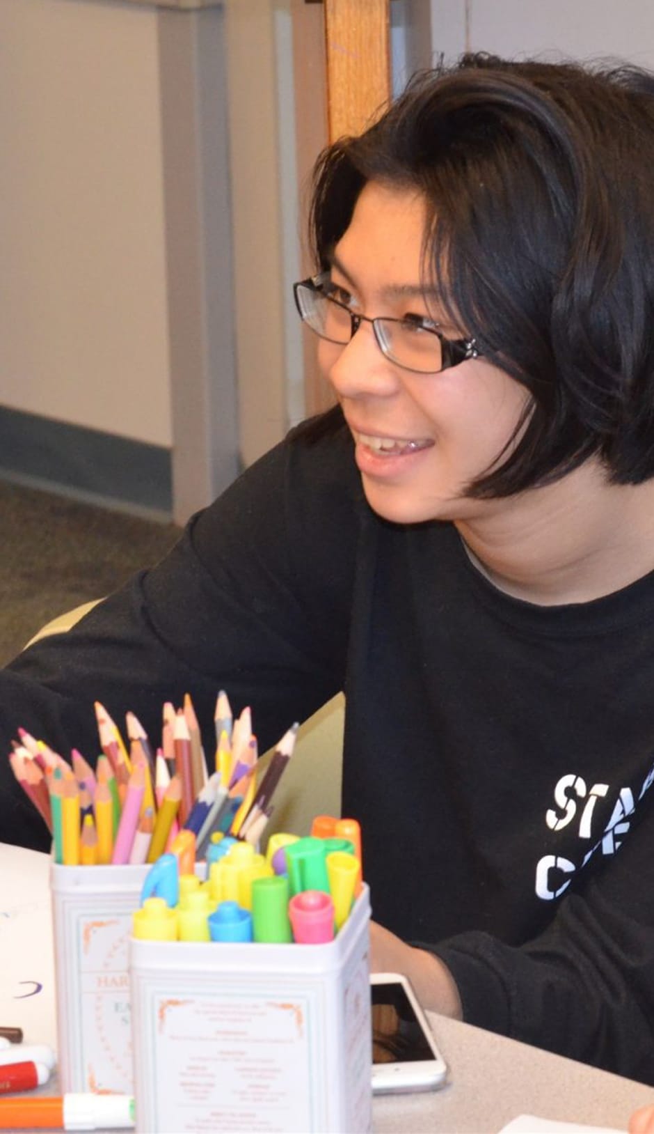 Student at Middle School Reading with colored pencils in front