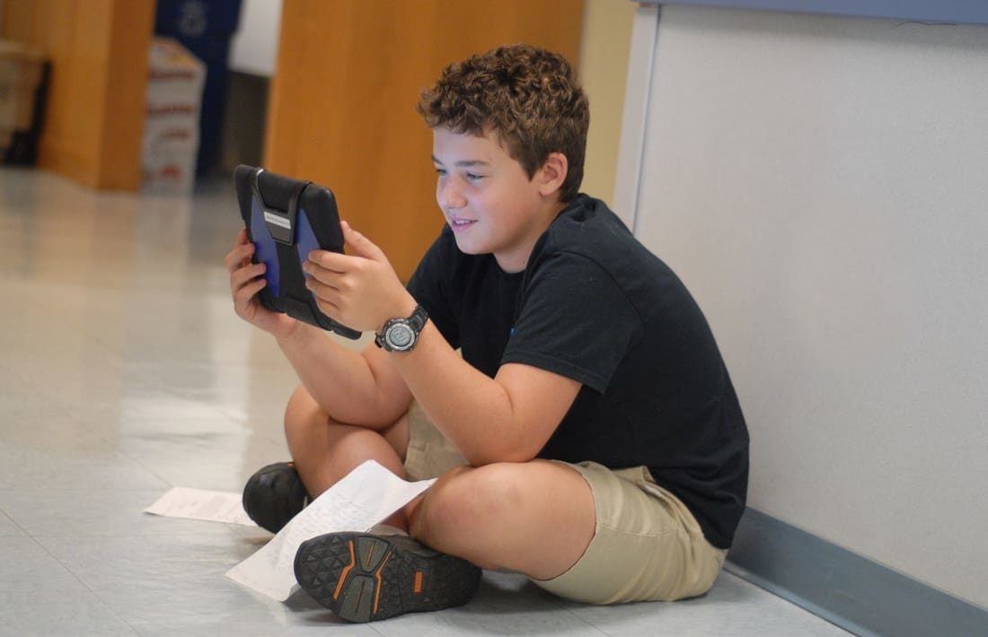 Middle school student in hallway practicing his writing