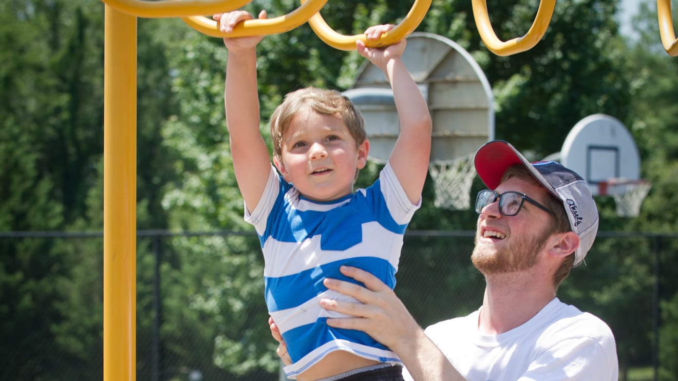 Boy hanging on rings at the playground