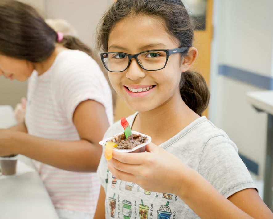 Girl eating pudding with gummy worms