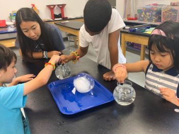 Students dropping solvent into a bowl of water