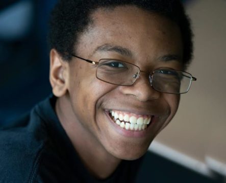 Male teen smiling and wearing glasses