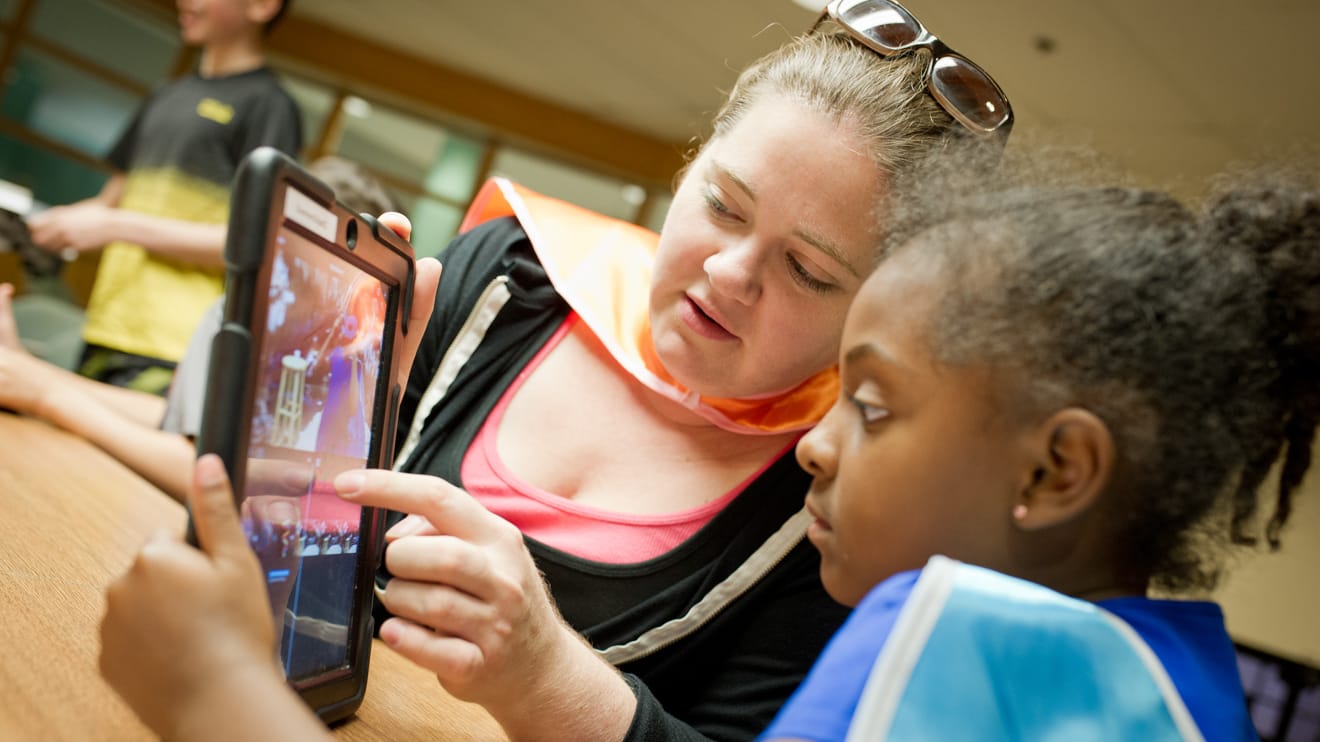 Staff showing a camper a virtual reality program