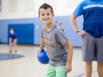 Boy holding a dodgeball in the gym