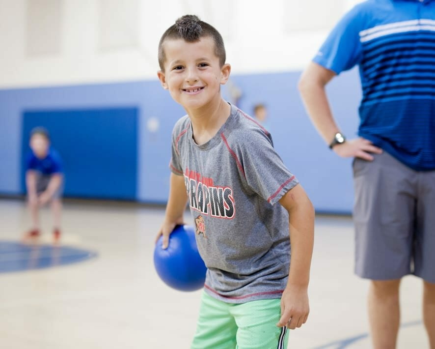 Boy holding a dodgeball in the gym