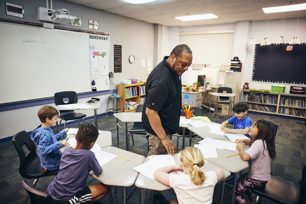 A teacher and a group of students in a classroom.