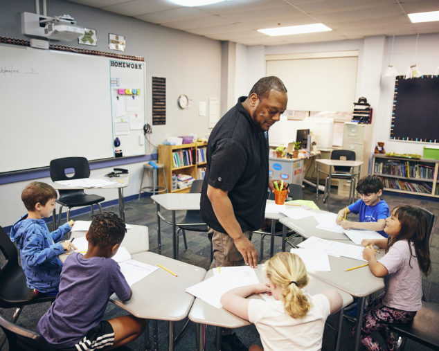 A teacher and a group of students in a classroom.