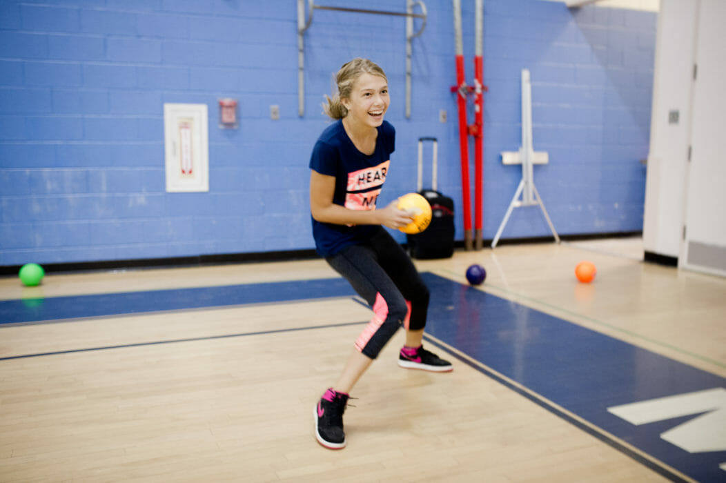 Girl throwing a dodgeball in the gym