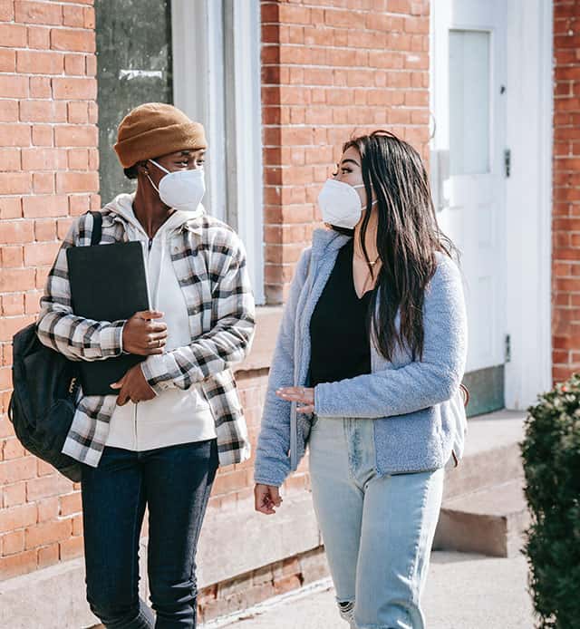 Two students wearing maskings walking together.