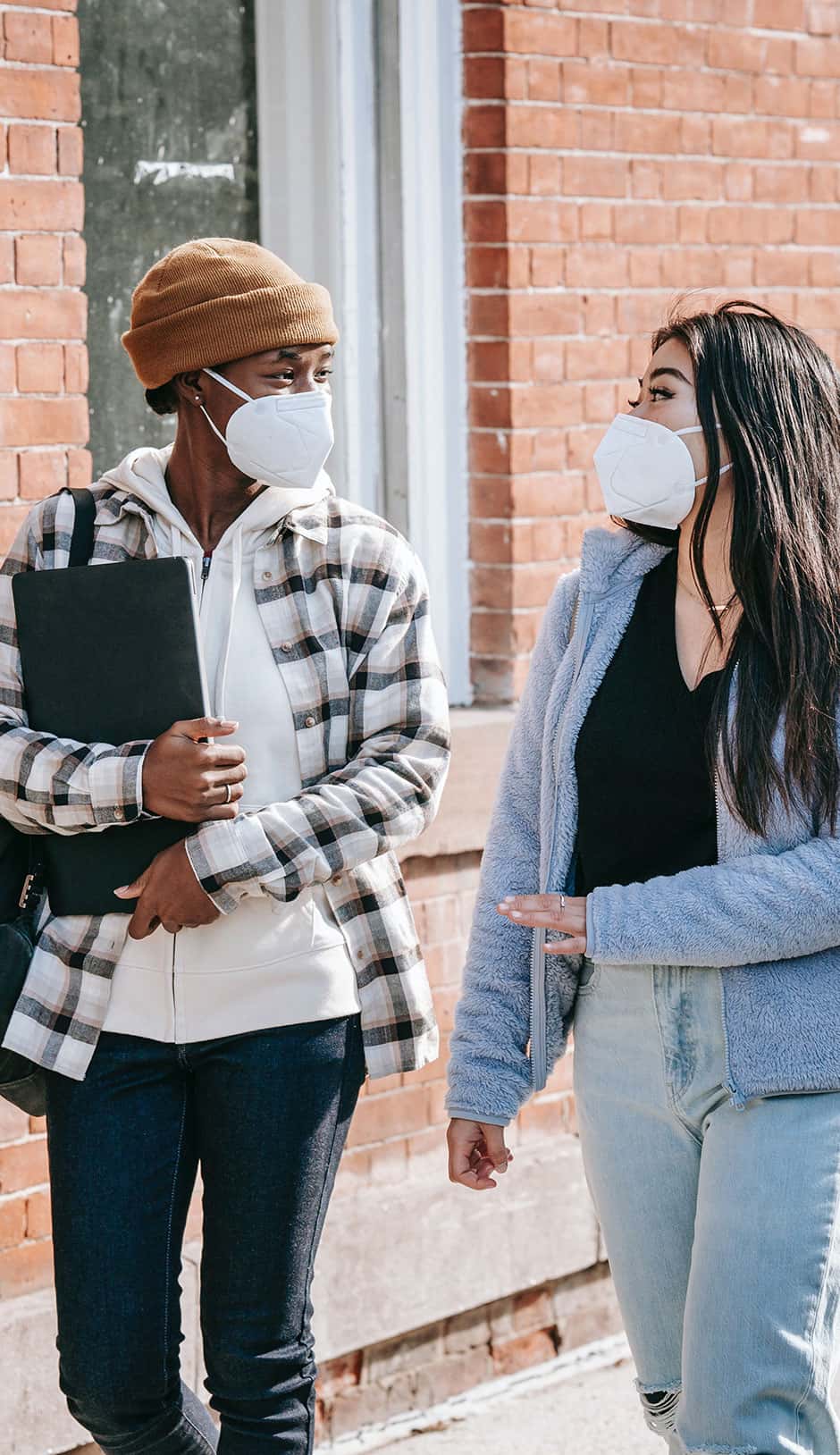 Two students wearing maskings walking together.